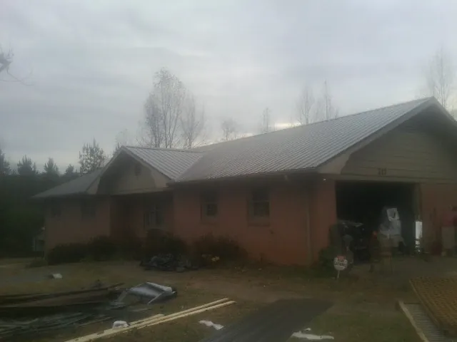 Gray metal roof on a stucco house with an attached garage in Southampton