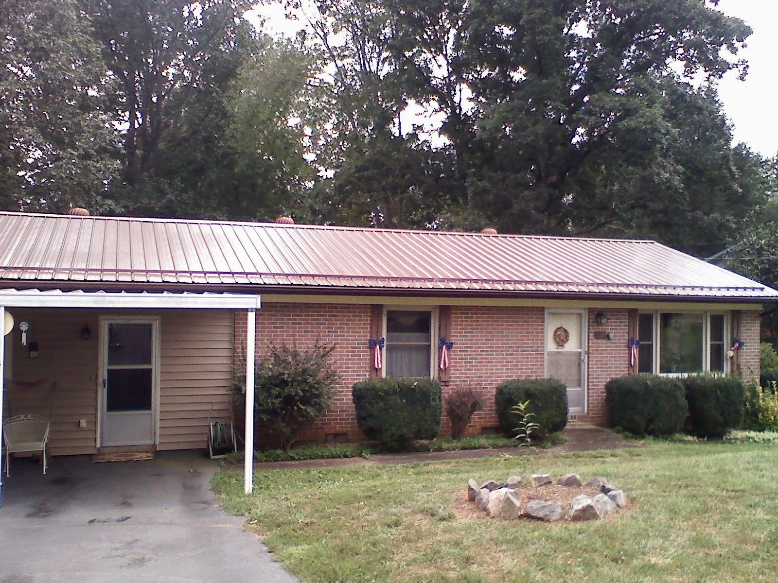 Bronze metal roof and carport on a brick ranch home — Roof Repair work by our crew in Southampton